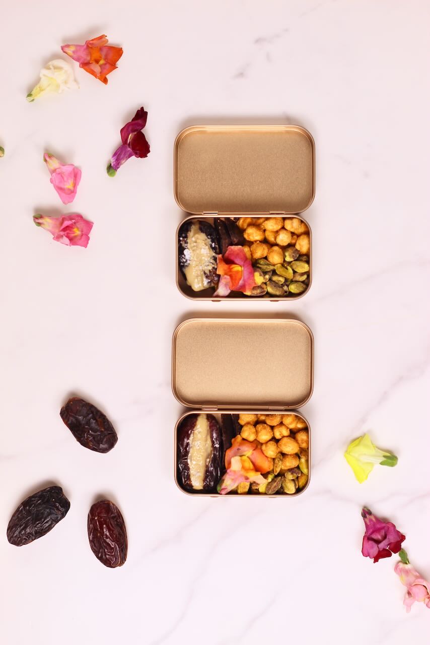Two snack tins with medjool dates on side